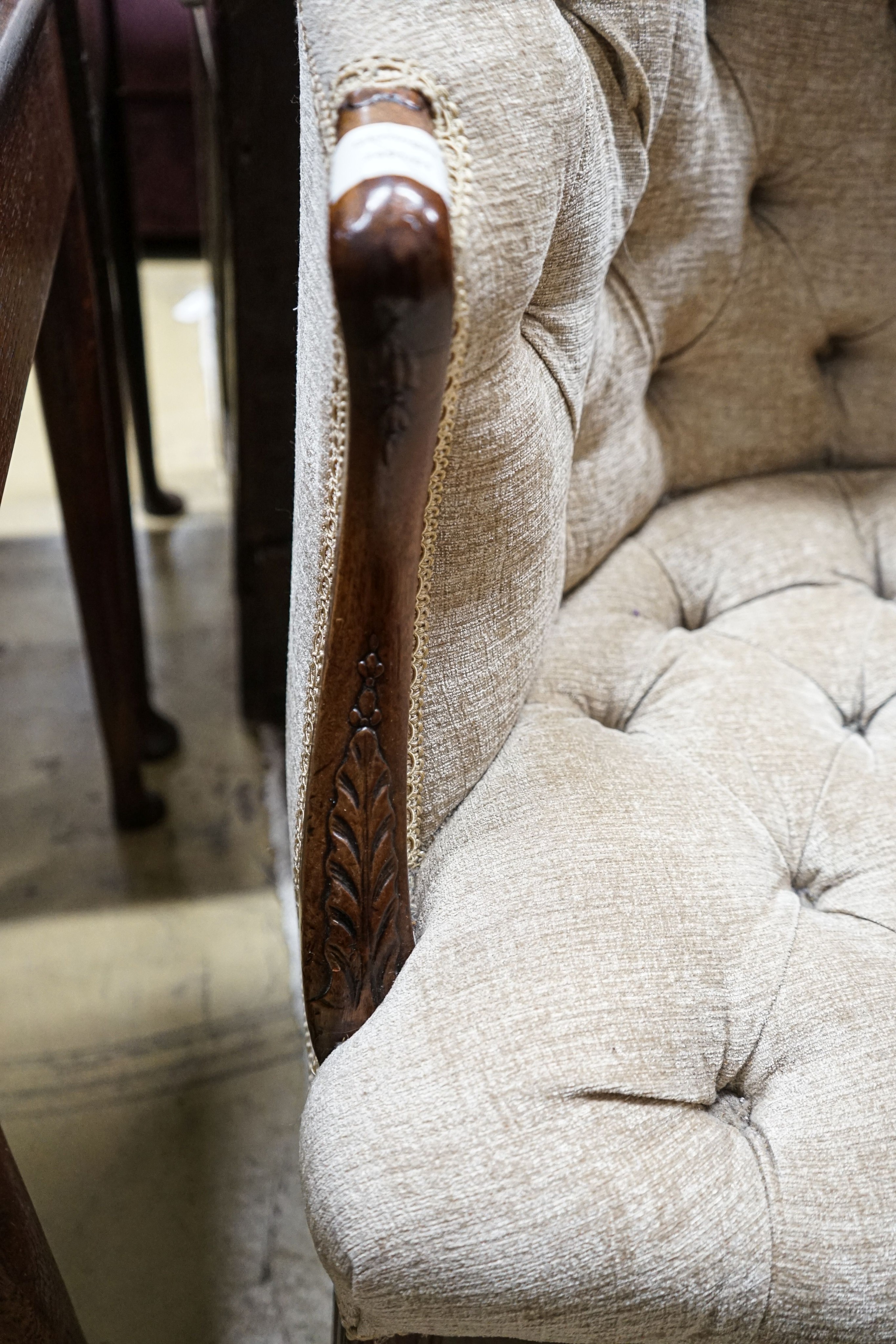 A George III Hepplewhite style mahogany tub chair, with later buttoned upholstery, acanthus carved arms and chamfered moulded squared legs, fitted brass castors, width 64cm, depth 50cm, height 97cm
